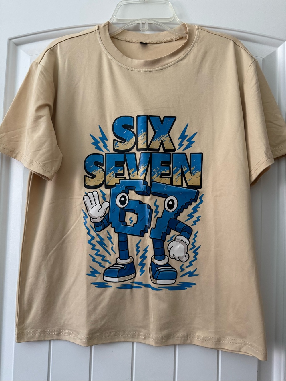Beige Graphic Tee with Blue 'SIX SEVEN' Character